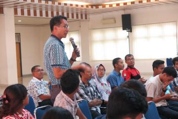 A faculty member asks a question at the lecture.